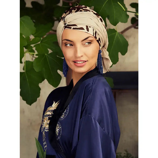 Woman modeling the HocSienna Soft Beige Giraffe Turban Set, styled with a blue kimono and tassel earrings.
